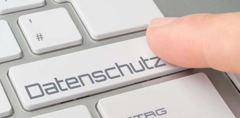 Ein Finger drückt eine Tastaturtaste mit der Aufschrift "Datenschutz", um auf die Bedeutung des Datenschutzes und der DSGVO-Fehlervermeidung auf Unternehmenswebsites hinzuweisen.
